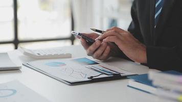 Financial analysts analyze business financial reports on a digital tablet planning investment project during a discussion at a meeting of corporate showing the results of their successful teamwork. video