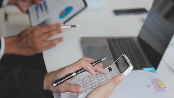 Financial analysts analyze business financial reports on a digital tablet planning investment project during a discussion at a meeting of corporate showing the results of their successful teamwork. video