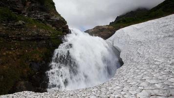 Alto cascata cascata queda dentro campo de neve video