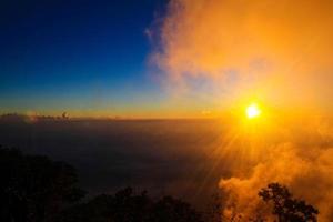 dorado ligero en boscoso y montaña con amanecer en Mañana niebla cubrir el selva colina en Tailandia foto