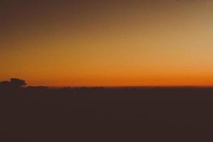 Sunset in sky and cloud, beautiful colorful twilight time with silhouette of mountain. photo