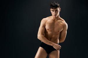 athletic man with pumped body dark panties studio photo