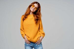 red-haired woman in yellow glasses posing fun lifestyle studio model photo