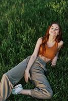 A young happy woman lying relaxed on the grass in the park, the lifestyle of a happy person without depression photo