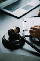 Business and lawyers discussing contract papers with brass scale on desk in office. Law, legal services, advice, justice and law concept picture with film grain effect photo