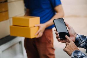Startup small business entrepreneur of freelance Asian woman using a laptop with box Cheerful success Asian woman her hand lifts up online marketing packaging box and delivery SME idea concept photo