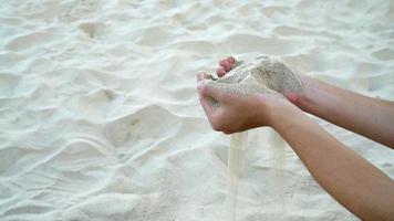 Sand im zwei Hand mit sandig Fußboden Hintergrund ,langsam Bewegung Bewegung video