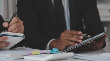 Financial analysts analyze business financial reports on a digital tablet planning investment project during a discussion at a meeting of corporate showing the results of their successful teamwork. video