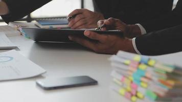 Financial analysts analyze business financial reports on a digital tablet planning investment project during a discussion at a meeting of corporate showing the results of their successful teamwork. video