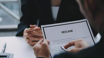 Businessman or job seeker review his resume on his desk before send to finding a new job with pen, necktie, glasses and digital tablet. video