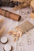 Handmade cardboard Scandinavian divination runes fall out of the pouch on the table vertical view photo