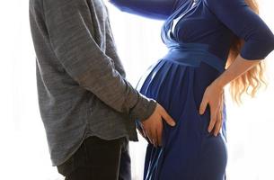 el embarazo. masculino manos toque el barriga de un embarazada mujer. foto