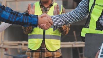 Two business man construction site engineer. Engineering objects on workplace with partners interacting on background video