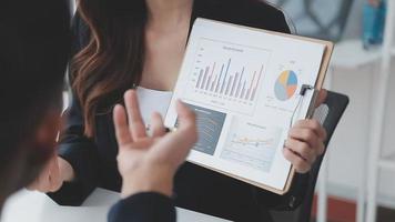 Financial analysts analyze business financial reports on a digital tablet planning investment project during a discussion at a meeting of corporate showing the results of their successful teamwork. video