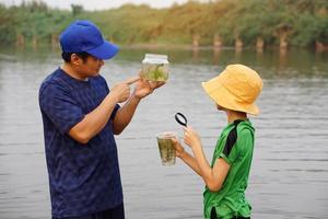 asiático hombre profesor y estudiantes son explorador agua desde naturaleza fuente. concepto, ecología y ambiente estudiar. al aire libre verano acampar actividad. educación. aprendizaje por haciendo. vida experiencia. foto