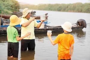 asiático hombre profesor y estudiantes son explorador agua desde naturaleza fuente. concepto, ecología y ambiente estudiar. al aire libre verano acampar actividad. educación. aprendizaje por haciendo. vida experiencia. foto