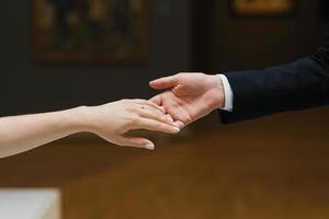 The groom extends his hand to the bride. Close-up photo