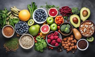 Healthy food clean eating fruit, vegetable, seeds, superfood, cereals, leaf vegetable on black wood background with copy space, top view. . photo