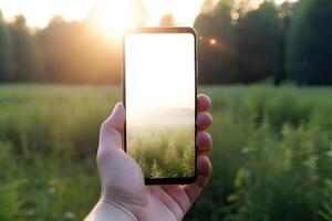 Close up view of hands holding mock up smart phone with green blurred background. photo