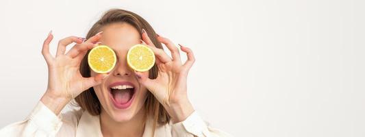 Woman holding two slices of orange photo