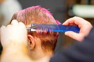 Woman with pink hair getting short haircut photo