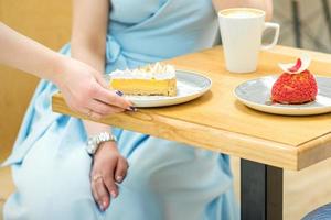 Waitress puts pastry on table photo