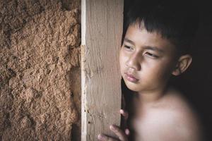 retrato de un pobre pequeño Tailandia chico perdido en profundo pensamientos, pobreza, pobre niños, violencia en contra niños. foto