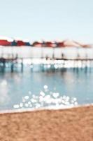 Blurred defocused beach with pier, parasol, sea with bokeh background. Rest, travel. Vertical. Copy space photo