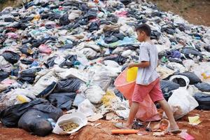 los niños pobres recogen basura para la venta debido a la pobreza, el reciclaje de basura, el trabajo infantil, el concepto de pobreza, el día mundial del medio ambiente, foto