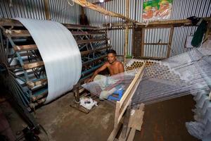 Bangladesh August 05, 2019 A factory worker makes white yarn spools for making clothes at Narsingdi, Bangladesh. photo