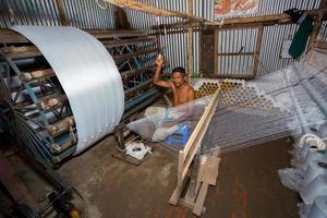 Bangladesh August 05, 2019 A factory worker makes white yarn spools for making clothes at Narsingdi, Bangladesh. photo