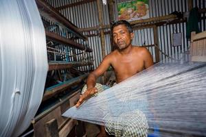 Bangladesh August 05, 2019 A factory worker makes white yarn spools for making clothes at Narsingdi, Bangladesh. photo