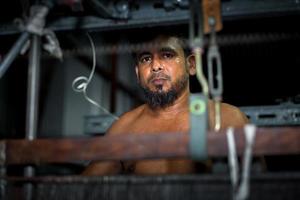 Bangladesh August 05, 2019 Portrait of a yarn factory worker operating a yarn machine at Narsingdi, Bangladesh. photo