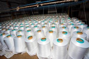 A pattern of white cotton spools with threads. An old system manual loom machine for clothing. photo