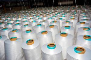 A pattern of white cotton spools with threads. An old system manual loom machine for clothing. photo