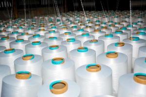 A pattern of white cotton spools with threads. An old system manual loom machine for clothing. photo