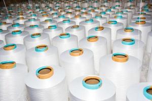 A pattern of white cotton spools with threads. An old system manual loom machine for clothing. photo