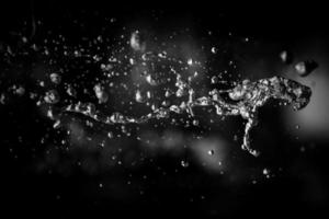 Water liquid splashing on isolated black background. photo