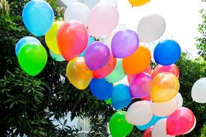 Colorful balloons filled with gas tied to the thread are flying. photo