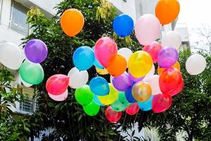 Colorful balloons filled with gas tied to the thread are flying. photo