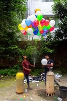 Bangladesh septiembre 08, 2020 dos globo vendedores son inyectando gas dentro algunos vistoso globos mediante dos gas cilindros a dhaka, bangladesh foto