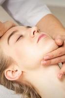 Woman receiving head and chin massage photo