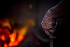 inseguro trabajador manos. un local acero máquina partes haciendo yarda trabajador derritiendo chatarra en caliente horno. foto