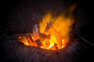 Unsafe worker hands. A local steel machine parts making yard worker melting scrap on hot furnace. photo