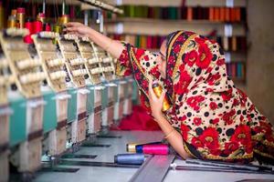 Bangladesh August 6, 2019 A Bangladeshi woman garments worker working with Computerized Embroidery Machine at Madhabdi, Narsingdi, Bangladesh. photo