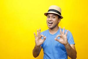 Portrait of Hipster young man young happy man casual dress blue striped t-shirt and wear a hats. Gesture emotion extend the arms shy modest on studio portraits set color yellow background. photo