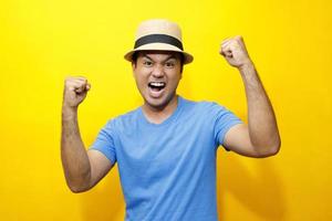 Portrait of Hipster young man young happy man casual dress blue striped t-shirt and wear a hats. Gesture emotion extend the arms shy modest on studio portraits set color yellow background. photo