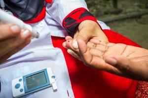 mujer comprobación azúcar nivel con glucómetro utilizando un sangre muestra a narsingdi, bangladesh aprender a utilizar un glucómetro concepto de diabetes tratamiento. foto