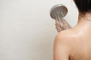 mujer tomando ducha y Lavado pelo con champú foto