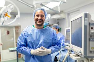 anestesista trabajando en operando teatro vistiendo protector engranaje comprobación monitores mientras sedante paciente antes de quirúrgico procedimiento en hospital foto